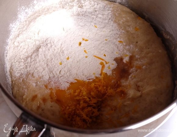 Для второго теста подготовить все необходимое, сливочное масло заранее выложить, чтобы оно стало комнатной температуры. В дежу миксера, где уже находится подошедшее первое тесто, добавить желток, ваниль, муку, соль, мелко натертую цедру апельсина и воду.