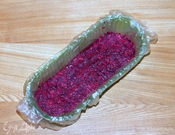 Формочку застелить пищевой пленкой и выложить свекольную смесь.
