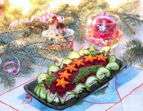 Из огурца вырезаем гирлянду и мелко нарезаем укроп. Украшаем салат.
