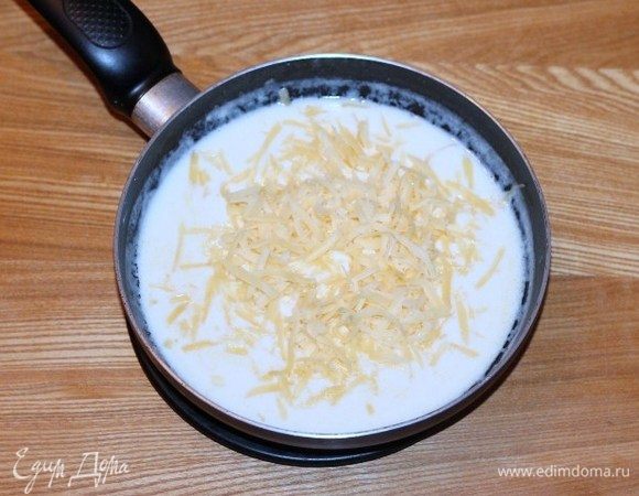 В молочную смесь добавить яйцо, 2/3 части сыра, перемешать.
