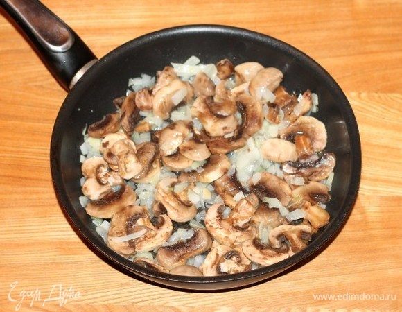 Подготовленные шампиньоны нарезать ломтиками и добавить к луку, посолить и поперчить, готовить до полной готовности.
