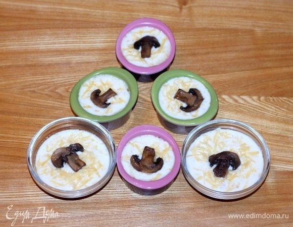 Залить грибы молочным соусом, посыпать орехами и оставшимся сыром, украсить ломтиком шампиньона.
