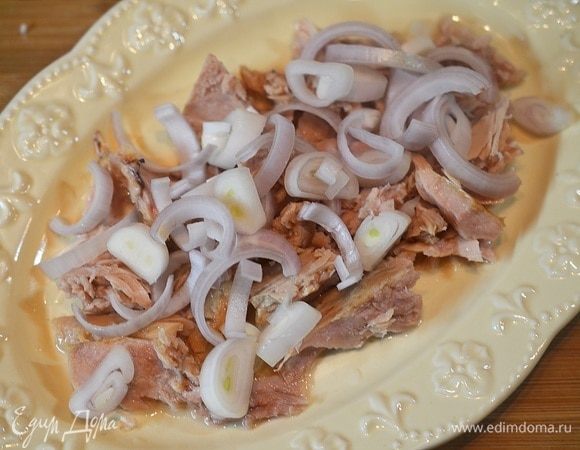 Овощи и яйцо отварите и почистите.
Первым слоем в блюдо выложим кусочки тунца, затем — нарезанный лук. Сверху выложим немного заправки.