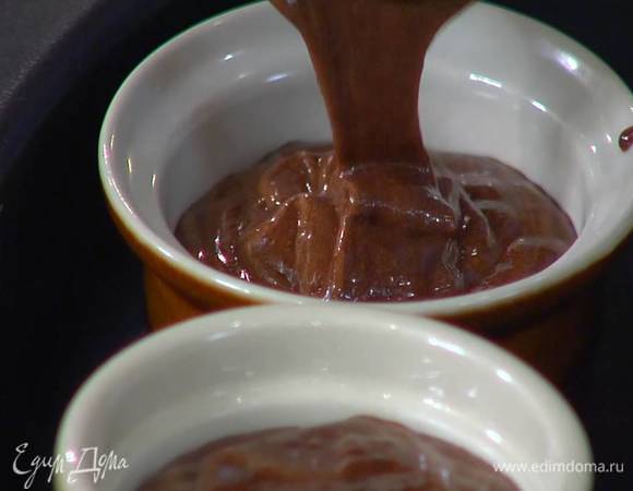 Разлить массу в небольшие керамические жаропрочные формы, поместить их в глубокий противень, влить горячую воду так, чтобы формы были погружены в нее на треть, и отправить в разогретую духовку на 12 минут.