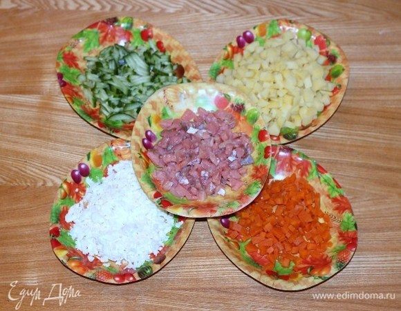 Картофель, морковь, яйцо отварить, охладить и очистить. Филе слабосоленой кеты, картофель, морковь нарезать небольшими кубиками. Огурец нарезать соломкой. Яйцо натереть на крупной терке.
