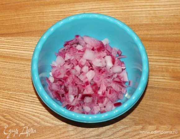 Репчатый лук очистить, мелко нарезать кубиками и выложить в миску. Залить лук теплой водой, добавить уксус, сахар и соль. Через 5–10 минут воду слить, лук охладить.

