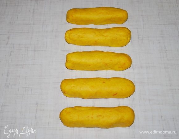 Из пяти рыжих кусочков сформируем колбаски длиной примерно 12 сантиметров. Из белых пяти кусочков раскатаем пласты толщиной примерно 2 мм, диаметром около 12–13 сантиметров.