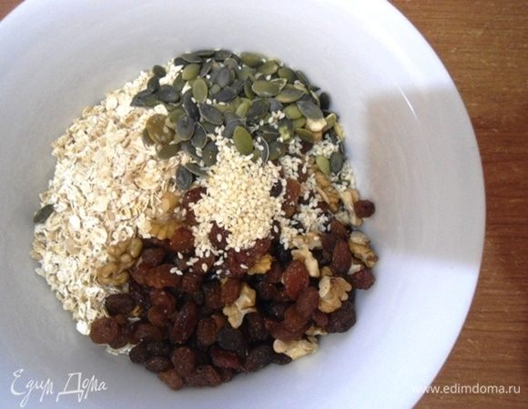 В миске смешать хлопья, орехи, семечки. Добавить изюм. Орехи подойдут любые, в оригинале был миндаль и семечки подсолнечника.