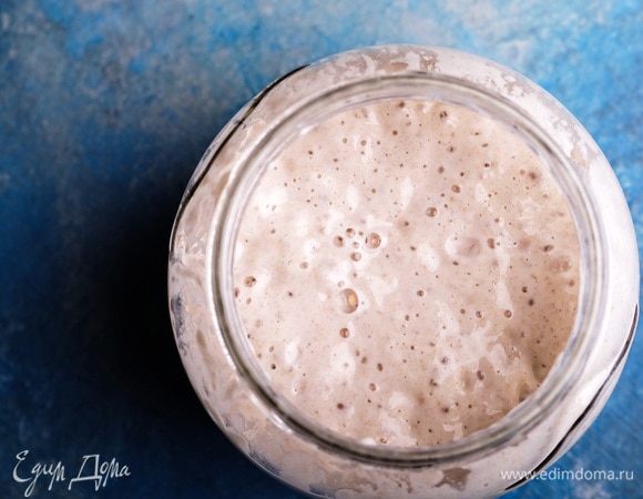 Заранее освежить закваску. Я беру 30 г закваски из холодильника, добавляю 90 г воды и 90 г муки 2-го сорта, перемешиваю и оставляю при комнатной температуре на 6–8 часов. Через указанное время закваска увеличится в 3 раза, станет воздушной и готовой к работе. Из этого количества потребуется 200 г готовой закваски.