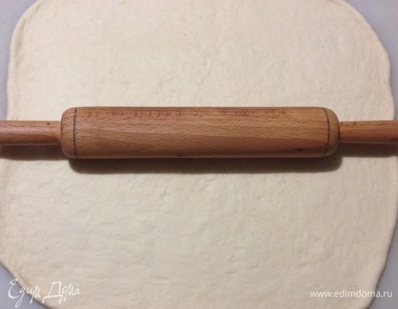Вынимаем тесто из миски, обминаем его так чтобы выпустить из него собравшийся воздух. Раскатываем ком теста в пласт прямоугольной формы.