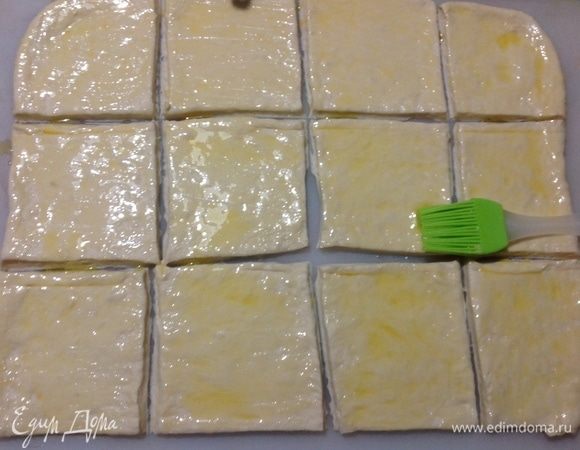 Теперь так, измеряем размер формы, в которой мы будем печь хлеб, в ширину и исходя из этого размера — ширины формы — мы разрезаем пласт на квадраты, у меня форма кирпичиком шириной 10 см, вот я и разрезала квадраты 10х10 см.
Оставшееся сливочное масло (70 г) надо растопить, потому что 50 г мы уже истратили в тесто. Теплым, не горячим, маслом смазываем квадраты теста с двух сторон. Еще немного растопленного масла может остаться, смажете им хлеб поверх, перед тем как ставить его в духовку.