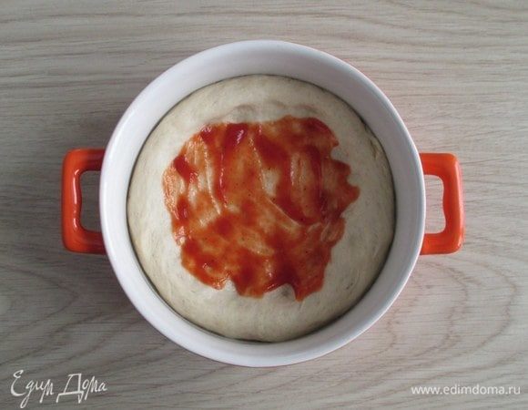 Смаженки пекутся или на противне, или в подходящих формах. Разделите тесто на заготовки (тут на две). 
Сформируйте из каждого куска дрожжевого теста лепешку, уложите ее на смазанный противень или в смазанную форму. Сделайте углубление под начинку, намажьте кетчупом.