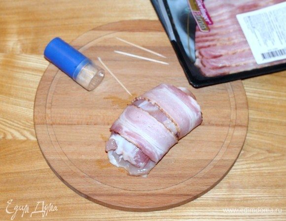 Каждый куриный рулетик обернуть двумя ломтиками бекона и закрепить деревянными шпажками. Жарить куриное филе в хорошо разогретом растительном масле до готовности. 