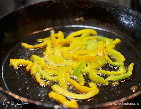 Перец нарежьте соломкой и обжарьте с добавлением масла 2 минуты.