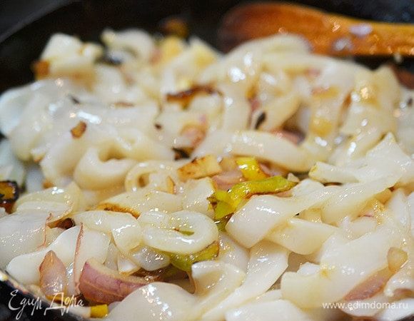 Добавьте кальмары, обжаривайте минуту.