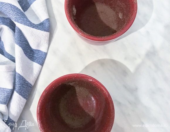 Разогреть духовку до 220°С. Подготовить керамические рамекины, смазать их сливочным маслом и присыпать какао-порошком.