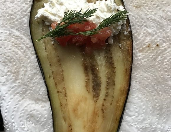 Выкладываем на каждый ломтик баклажана творожно-чесночную начинку, кусочки помидор, веточки укропа и сворачиваем в рулетики.