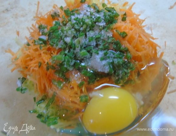 К картофелю с кабачком добавьте морковь, яйцо и мелко нарезанный зеленый лук.