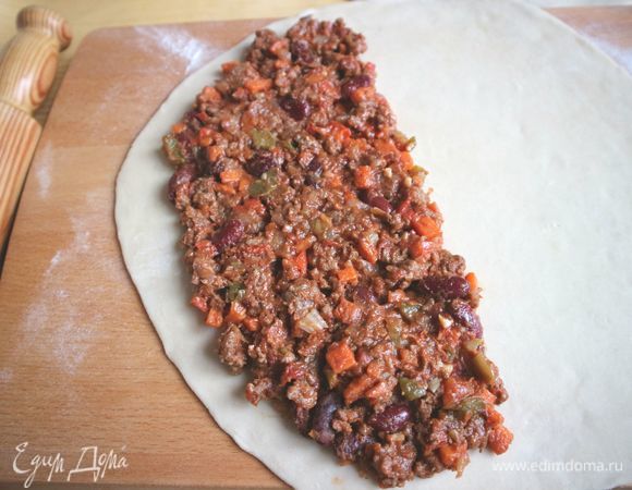 Положить начинку на половину круга из теста, отступив на 1 см от края.