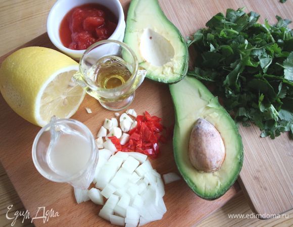 Лук и чеснок почистить, порезать, авокадо разрезать на половинки. Косточку удалить. Выдавить лимонный сок. Красный перец чили порезать. 