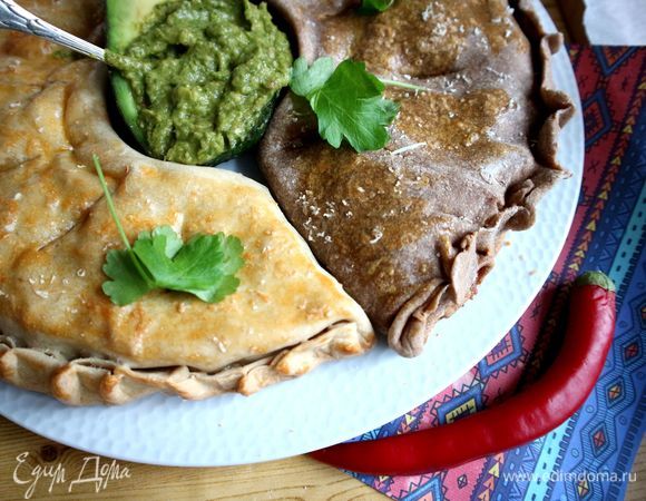 Положить половинку авокадо с соусом гуакамоле в центр между двумя пиццами. Украсить блюдо зеленью петрушки. Пиццу Кальцоне иногда называют пирогом Кальцоне. Трудно с этим не согласиться.