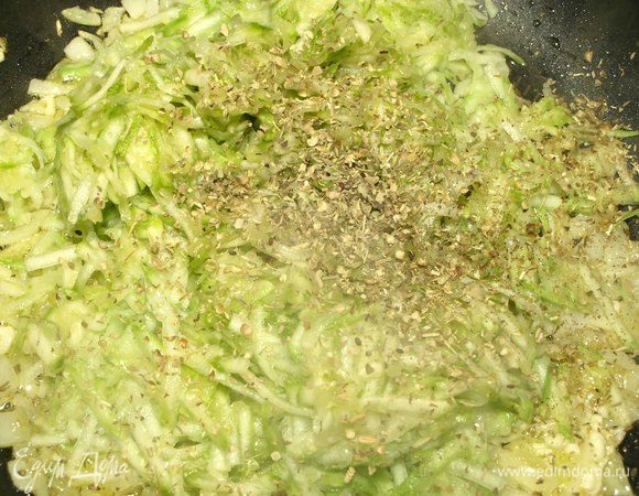 Добавить тертые кабачки, сухой орегано, сухой базилик, соль, перец. Перемешать. Готовить 3-4 минуты. Крышкой не закрывать.