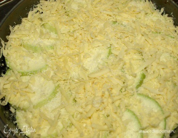 Дно формы (22 см) смазать оставшимся оливковым маслом. Посыпать частью тертого пармезана. Сверху выкладываем кабачки и посыпаем сыром. Немного оставить сыра для яично-овощной смеси. По желанию посолить. 