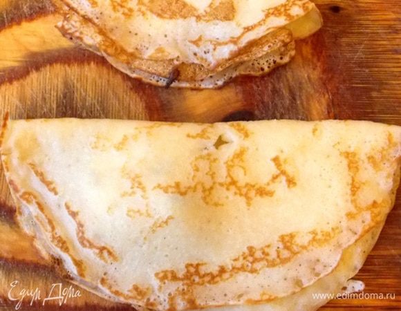 На одну половинку каждого блина положить немного начинки, ближе к одному краю, накрыть другой половиной и сложить снова пополам.