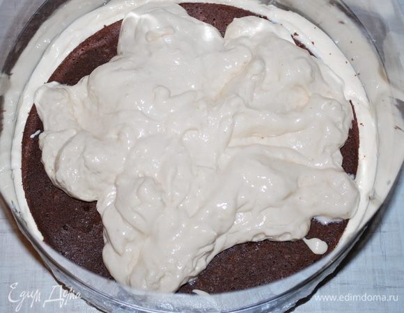 Собираем торт. Кольцо диаметром 22 см затянуть пленкой и изнутри выложить кольцо ацетатной пленкой, чтобы было удобно доставать торт.
1 слой — немного мусса, разровняем.
2 слой — «утопить» первый бисквит без орехов, чтобы мусс выступил по краям.
3 слой — выложить остатки мусса, разровнять спатулой.