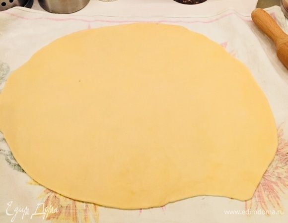 Достаем полотенце х/б, посыпаем мукой и раскатываем тесто довольно тонко, но без фанатизма (иначе яблоки прорвут тесто и сок будет вытекать), смазываем сливочным маслом (но не всем).