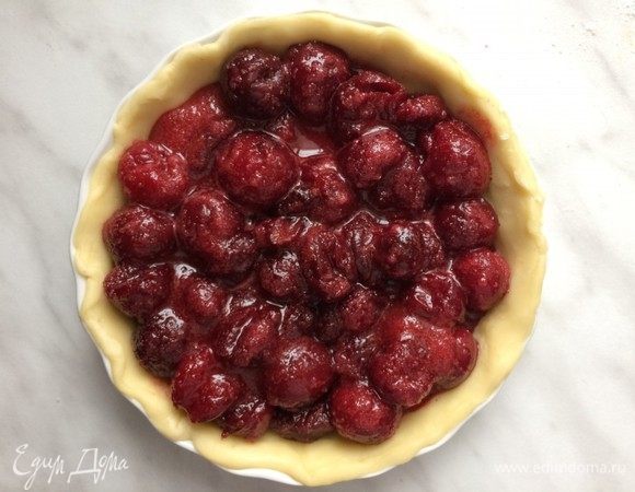 Достаньте из холодильника форму с тестом, выложите в нее вишневую начинку.