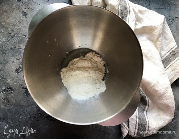 Остальную воду смешайте с маслом, добавьте дрожжевую смесь и муку. При помощи миксера с насадкой «крюк» или крепкой деревянной ложкой замесите тесто, только до увлажнения всей муки. Закройте миску пленкой и оставьте примерно на 15 минут.