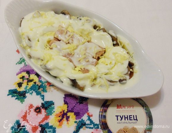 Сверху залить рыбу сметанным соусом и посыпать тертым сыром.