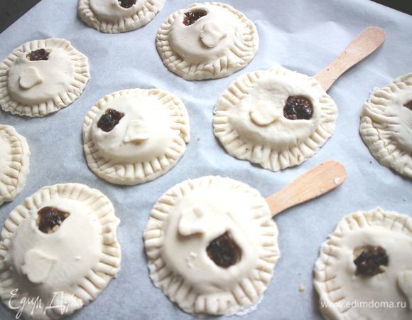Противень застелить бумагой для выпечки. Закрыть кружочками теста с «окошечками». Вилкой пройтись по краю печенья, скрепляя две половинки из теста. Смазать кисточкой желтком, смешанным с молоком. Выпекать при температуре 200°С около 30 минут до золотистого цвета.