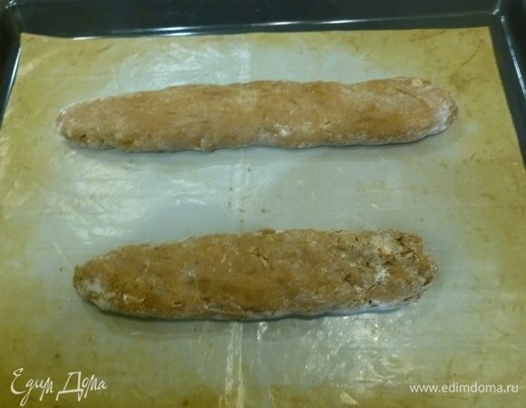 Разделить тесто на 2 части, скатать 2 колбаски диаметром 3–4 см. Выложить на застеленный пергаментом противень (или антипригарный коврик). Немного сплющить, чтобы печенье в итоге получилось овальной формы. Поставить в духовку на 25–30 минут. 