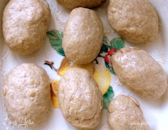 Рабочую поверхность припылить оставшейся пшеничной мукой, положить тесто, немного обмять и сформировать булочки. Если тесто липкое, то смажьте руки растительным маслом. Так легче будет справиться с тестом. Противень припорошить мукой и положить булочки.