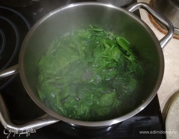 Шпинат опускаем на несколько минут в кипящую воду, затем откидываем на дуршлаг, отжимаем листья от лишней влаги.