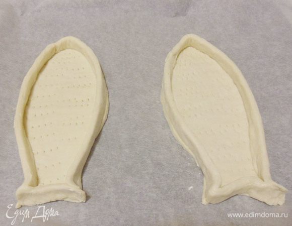 Проколоть тесто вилкой, кроме полосок по краям. Поставить в холодильник на 10 минут. Затем выпекать в разогретой до 200°С духовке около 15 минут, пока края хорошо не подрумянятся.