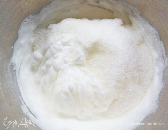 Белки взбить в устойчивую пену, затем добавить 185 г сахара и 10 г ванильного сахара, взбить до устойчивых пиков, белковая масса должна быть плотной и блестящей.