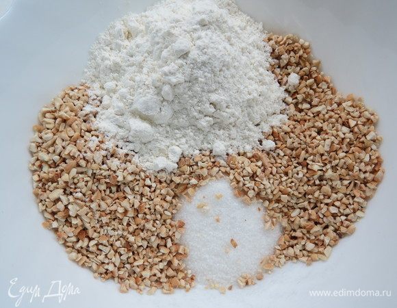 В отдельную миску сложить мелко порубленный обжаренный фундук, 45 г сахара и 45 г муки.  