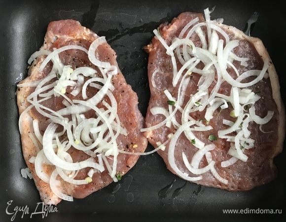 Лук очистите и нарежьте полукольцами. В миске смешайте лук с листочками тимьяна и тщательно перемешайте руками, чтобы вышел сок. Противень сбрызните маслом, выложите отбивные, сверху — слой лука.