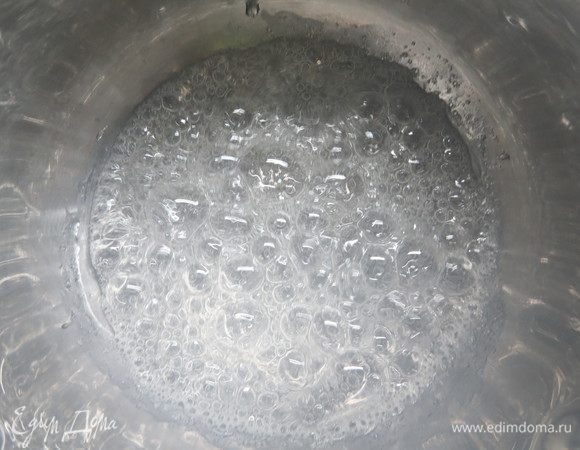 Готовим грильяж. В толстодонную кастрюльку или сотейник влить воду, всыпать сахар и довести до кипения на сильном огне, постоянно помешивая. 