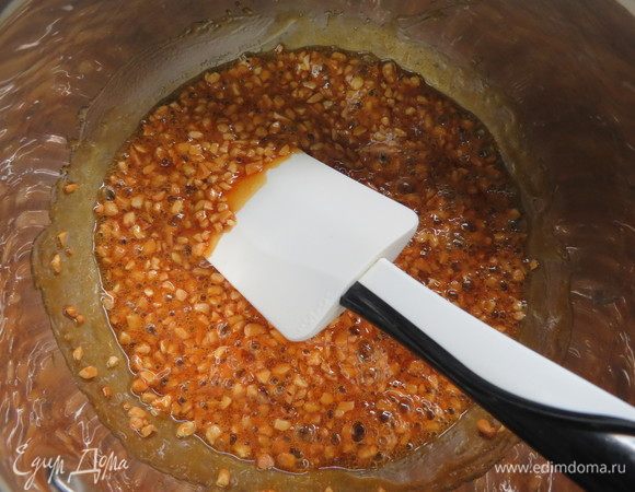 В карамелизированный сироп всыпаем орехи и перемешиваем. 