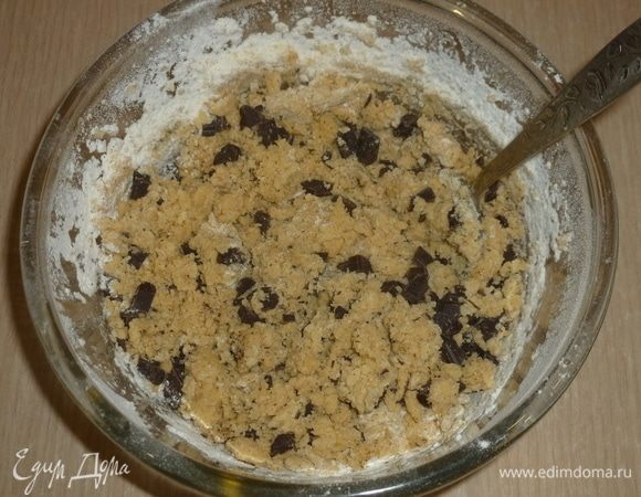 Шоколад нарезать ножом на маленькие кубики, вмешать в тесто. 