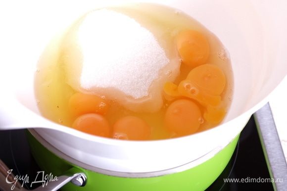 Соорудить водяную баню (миска в кастрюле с кипящей водой, дно миски не касается воды). В миску поместить яйца и сахар.