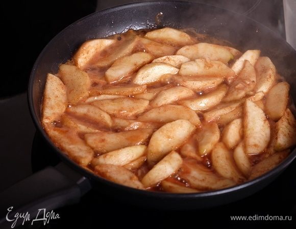 В большой сковороде растопить сливочное масло, выложить яблочные дольки, готовить яблоки на среднем огне примерно 10 минут — за это время сахар растопится, яблоки начнут карамелизоваться. Нужно следить, чтобы яблоки не превратились в кашу, то есть, готовить их до такого состояния, чтобы они были мягкие снаружи, чуть твердые внутри, хорошо держали форму.