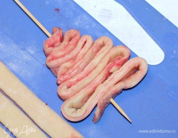 Берем шпажку и насаживаем полоски теста. У меня на каждую елочку ушло по 3 полоски теста. В результате получается 8–9 розовых елочек.
