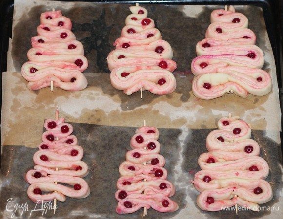Застилаем противень бумагой для выпечки и смазываем маслом. Силиконовый коврик не смазываем маслом. Выкладываем елочки на противень, украшаем ягодой (у меня замороженная брусника). 
