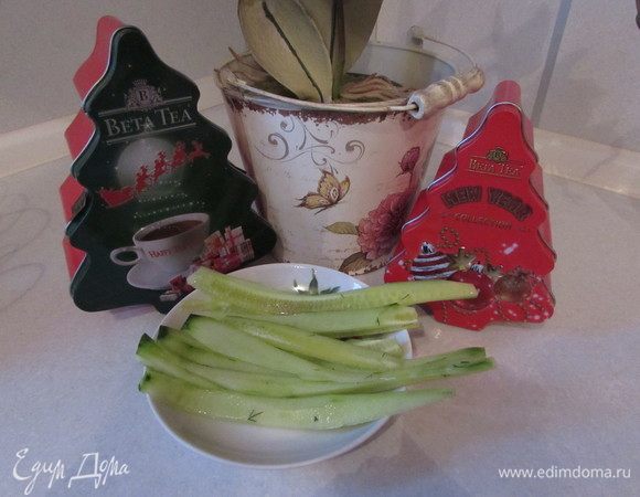 Нарезать огурцы тонкими длинными ломтиками.