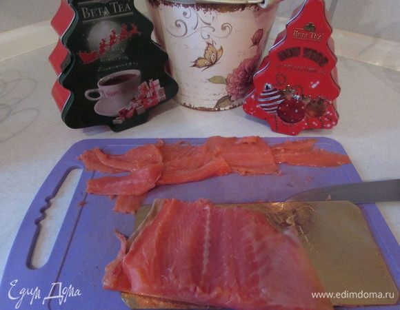 Нарезать ломтиками слабосоленого лосося.